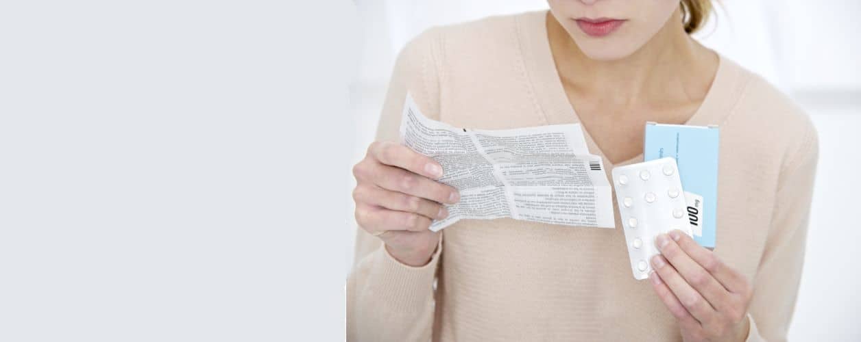 Mujer leyendo indicaciones de uso de medicamento