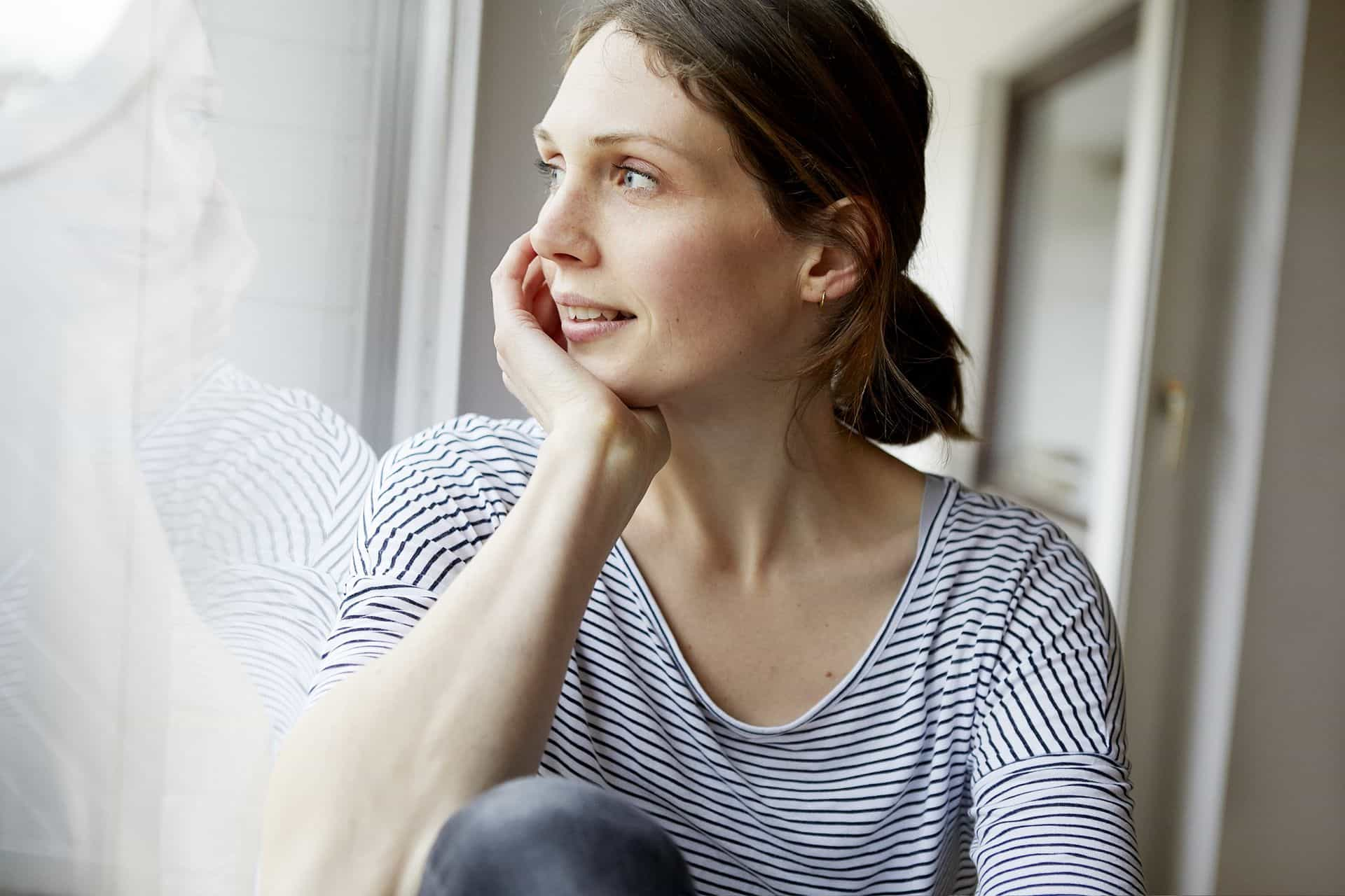 mujer viendo por la ventana